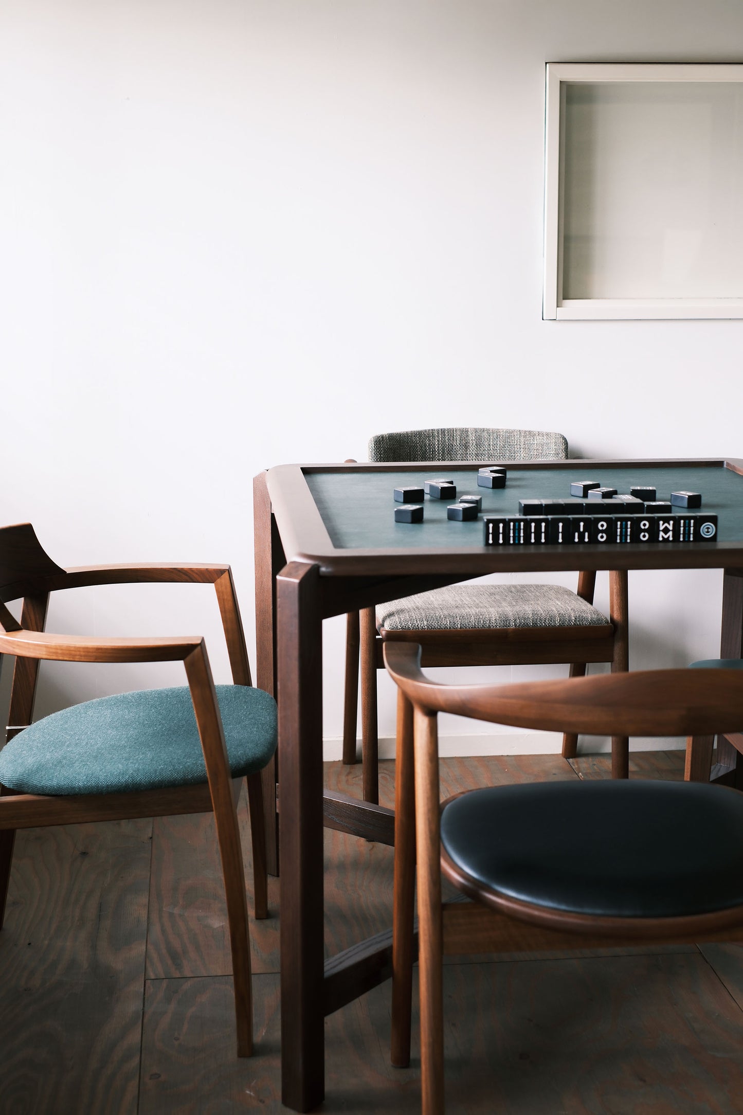 MJ88 Foldable Mahjong Dining Table – close front view in apartment setup with four wood chairs, solid Japanese ash wood top in mahjong mode 麻雀餐桌,日本製,位於公寓室內的正面視角,桌面使用北海道梣木,設為麻雀模式,搭配四張木椅。
