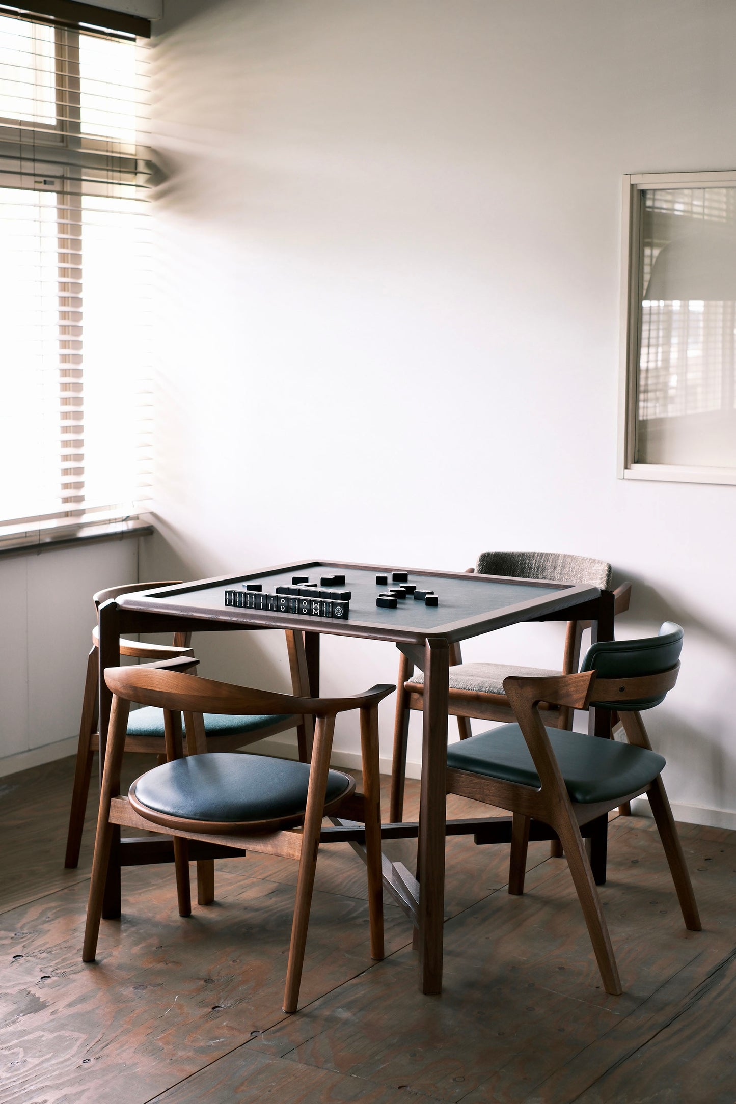 MJ88 Foldable Mahjong Dining Table – side view of home setup with four wooden chairs and natural light, stylish and compact design 麻雀餐桌,日本製,居家擺設側面視角,搭配四張木椅與自然光,設計簡約精緻。