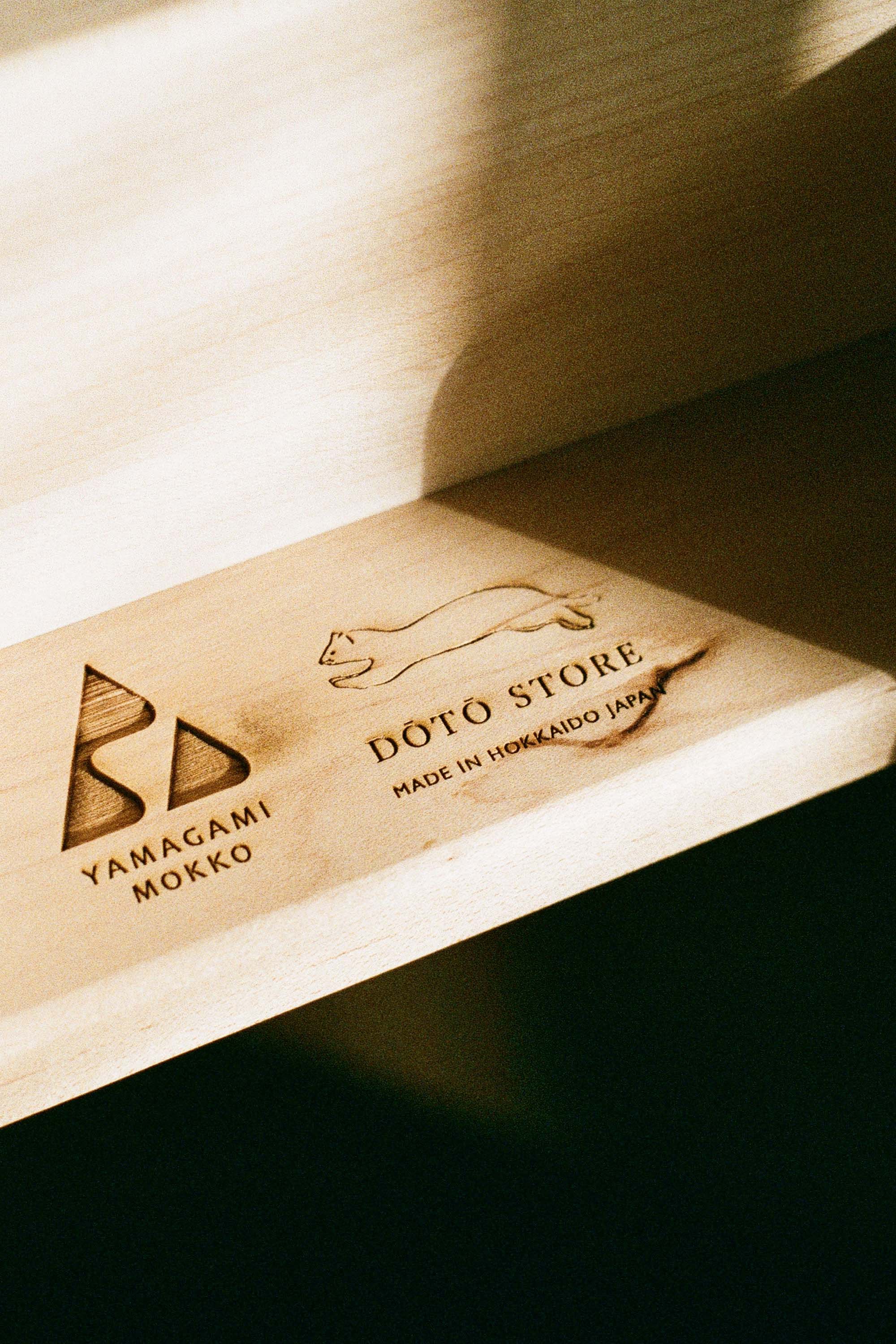 DOTO STORE 與 YAMAGAMI MOKKO 聯Co-branded logo engraving of DOTO STORE and YAMAGAMI MOKKO, representing Hokkaido craftsmanship. 名品牌燒印標誌，展現北海道製的工藝精神。