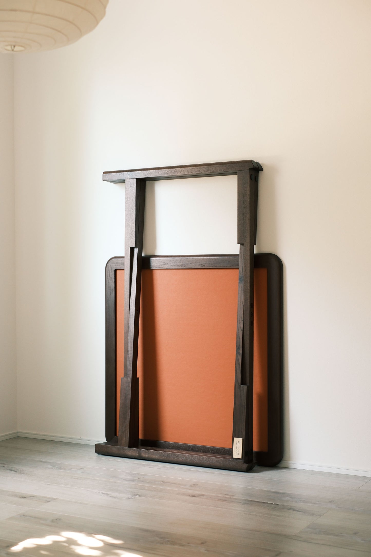 Folded MJ88R mahjong table leaning against the wall, showing its slim compact profile
MJ88R 摺疊麻雀桌收合靠牆，展示纖薄慳位外形