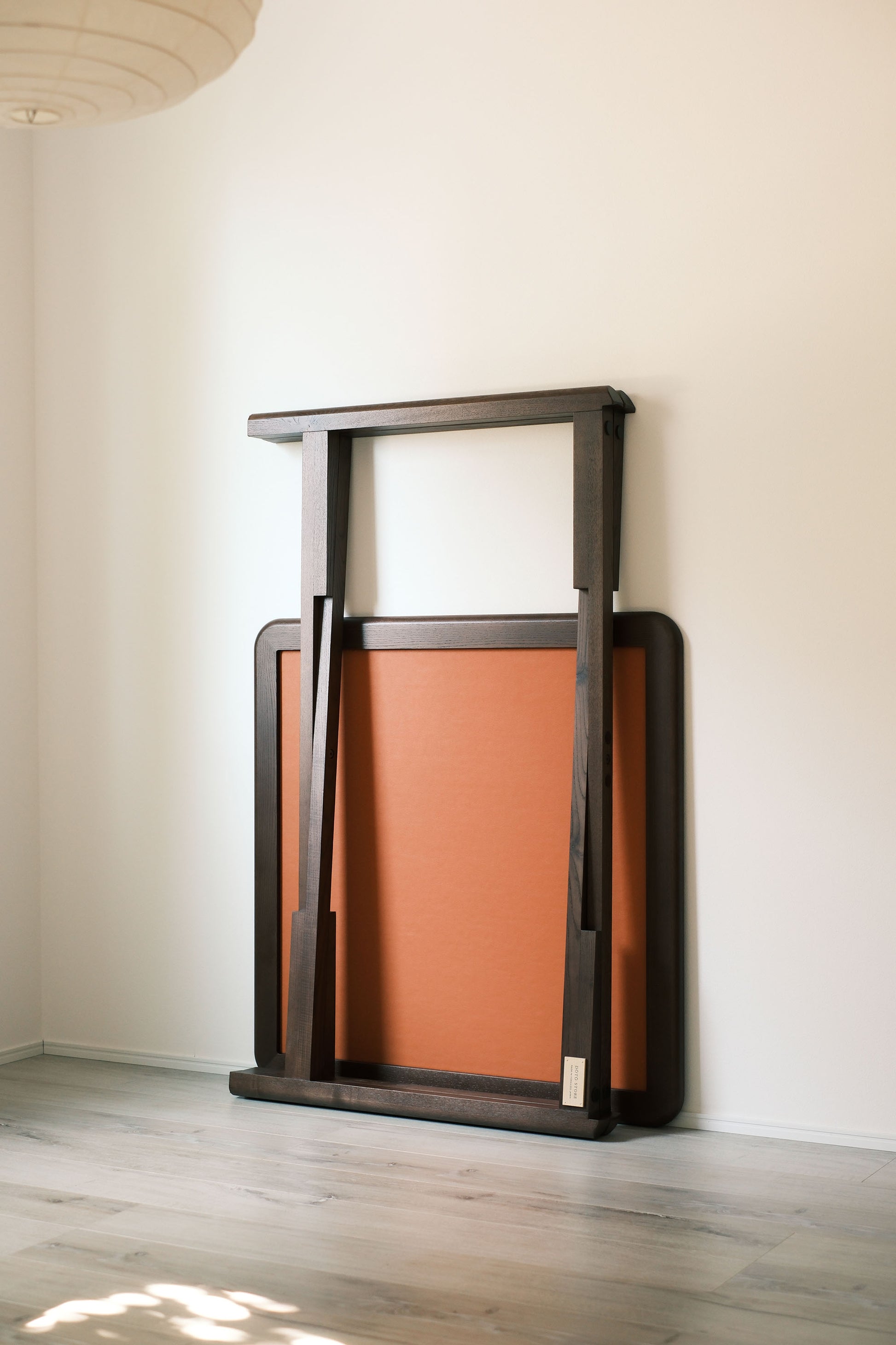 Folded MJ88R mahjong table leaning against the wall, showing its slim compact profile
MJ88R 摺疊麻雀桌收合靠牆，展示纖薄慳位外形