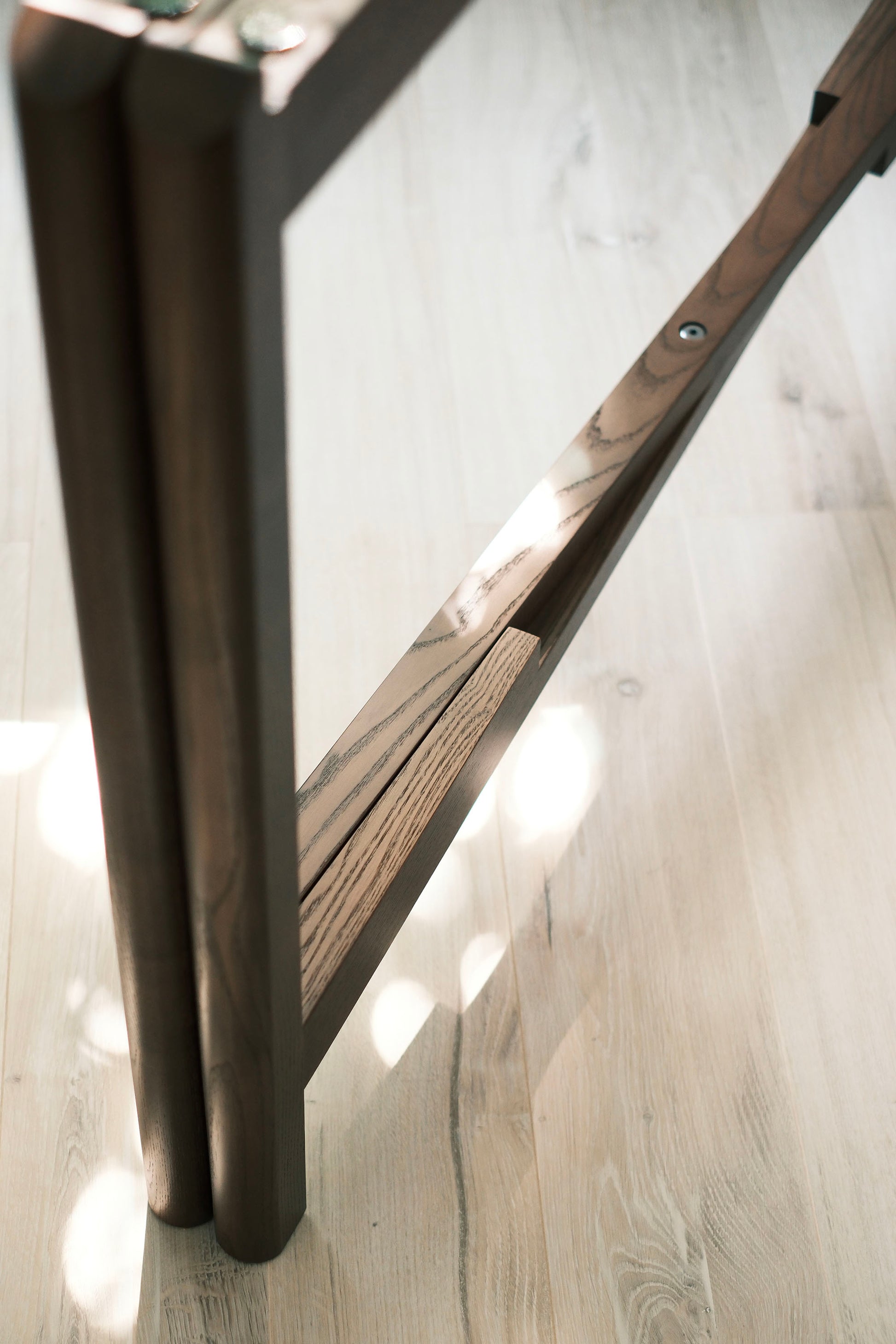 Close-up of the folded MJ88R mahjong table frame on oak flooring, showing the wood grain detail
MJ88R 摺疊麻雀桌桌框特寫，展示橡木木紋細節