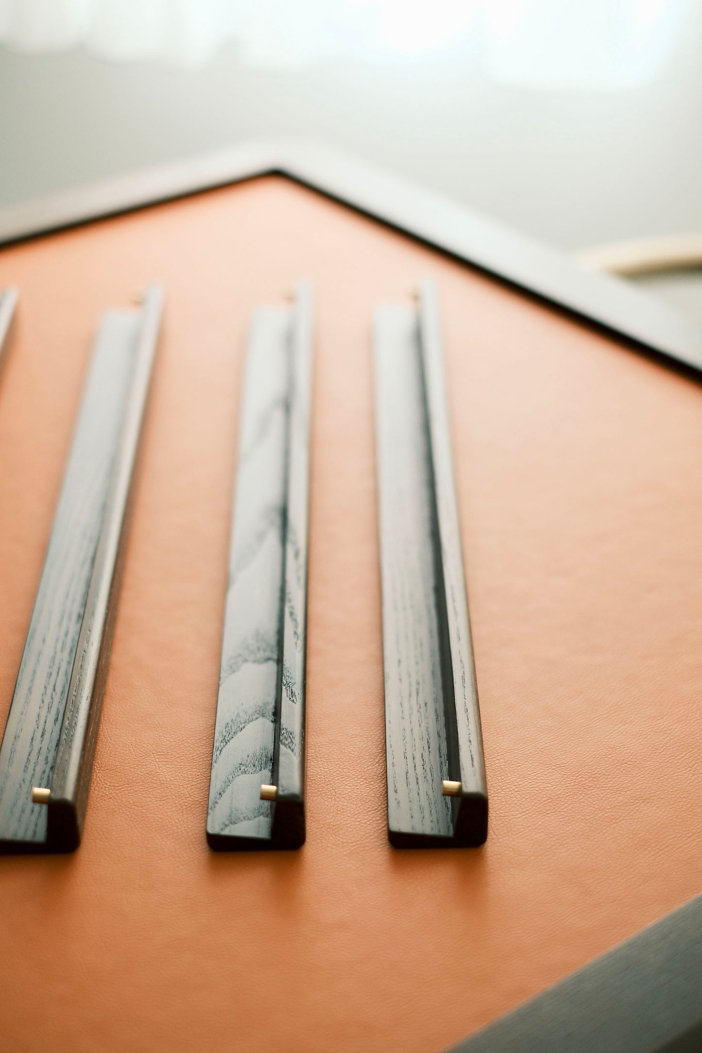 Close-up of MJ88R solid oak mahjong tile racks on the foldable mahjong table's leather playing surface. MJ88R 實木橡木麻雀牌尺特寫，置於摺疊麻雀桌皮革桌面上。